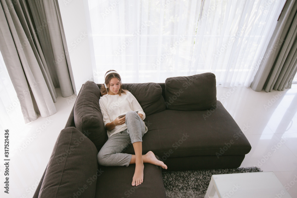 Sticker Teen girl relaxing with tablet pc on couch