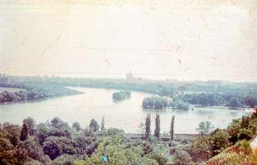 Vintage photo with a view of the bend of the river surrounded by green banks