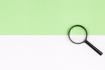 Magnifying glass on a white-green background. Top view.