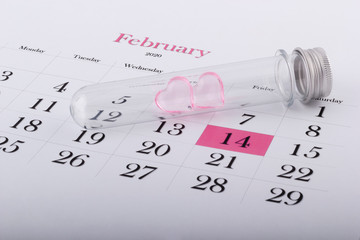 Two hearts in a flask and a calendar sheet with a pink mark February 14 - Valentine's Day. Happy Valentine's day. Valentine's day concept. Valentine's Day 2020.