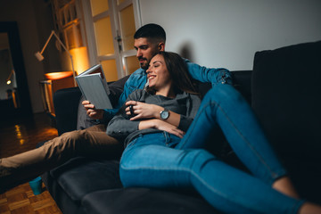 romantic couple reading book at home