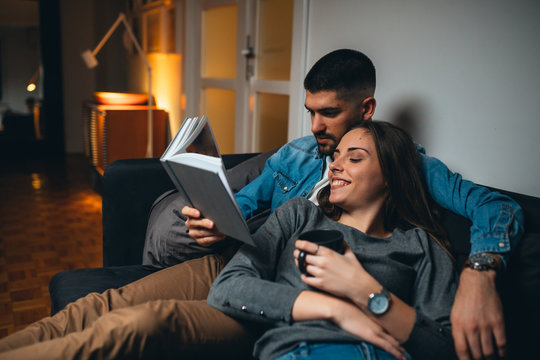 romantic couple reading book at home
