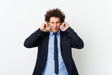 Young business curly man against white background covering ears with hands.