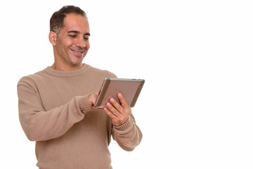 Mature happy Persian man using digital tablet