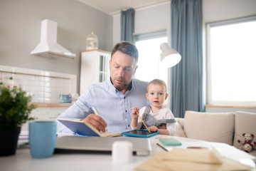Bearded man in a blue shirt holding his kid and looking concentrated