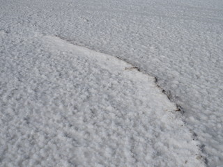 white surface of the lake covered with salt at sunrise
