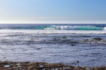 Ocean waves crashing onto the rocks in the sunset