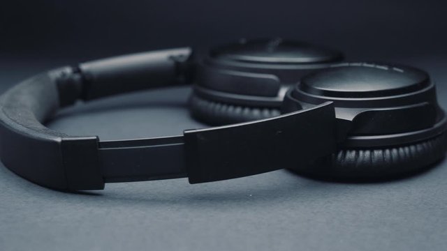 headphones on a dark background, moving the camera from right to left.