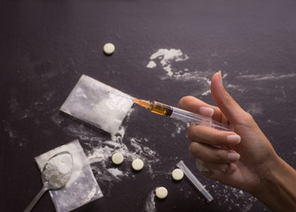 Heroin, injection, old spoon,  injection needle with hand asian women on dark wooden black...