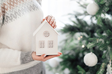 Woman hand holding a mini wooden house.