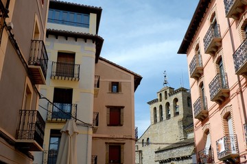 Low pastel colored houses with windows and carved metal balconies. Jaca old town. Huesca, Aragon, Spain