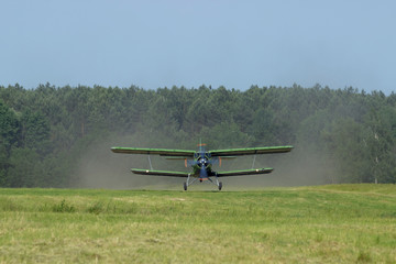 The plane comes in for a landing in the meadow.