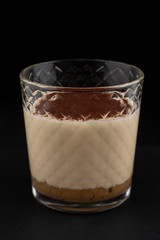 Classic tiramisu in a glass on black background