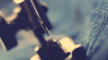 sewing machine and item of clothing macro, blue toned