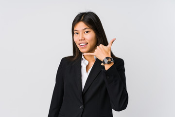 Young asian business woman showing a mobile phone call gesture with fingers.