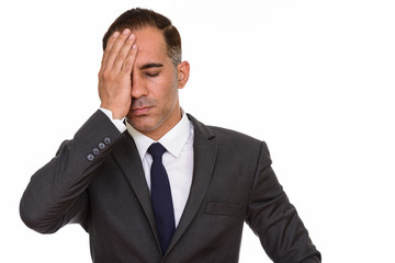 Face of stressed mature Persian businessman having headache