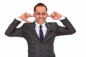 Stressed mature Persian businessman in suit covering ears