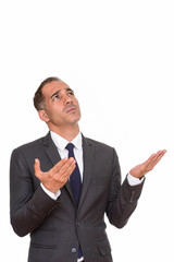 Stressed mature Persian businessman looking up with arms raised