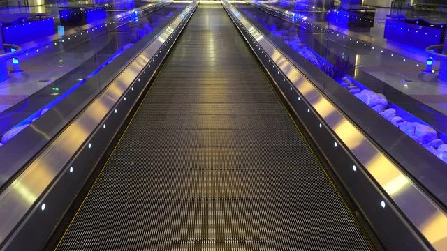 Moving walkway, moving sidewalk, moving pavement, travelator, horizontal escalator, moveator, or auto walk at an international airport terminal, in modern office centre