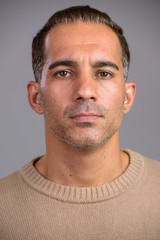 Face of mature handsome Persian man looking at camera