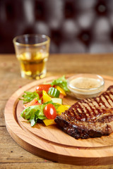 grilled beef steak with sauce and vegetables