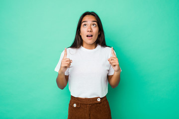 Young mixed race indian woman isolated pointing upside with opened mouth.