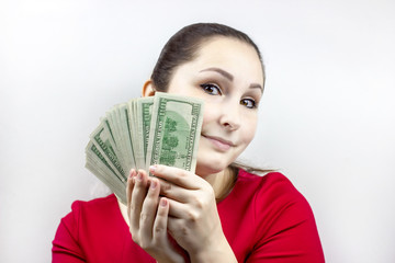Pretty young caucasian brunette woman in casual red dress holding american dollars in her hands. Finance and money, earnings and savings, salary and income concept.