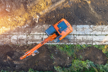Excavator on caterpillars in the foundation pit during the construction of the building foundation,...