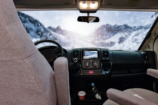 Winter camper with big window and free space for your decoration.Mountains with sun light and snow flakes 