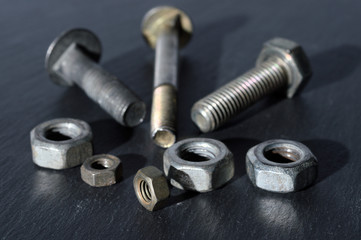 old bolts and nuts on a dark background.