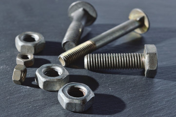 old bolts and nuts on a dark background.