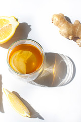 Fototapeta na wymiar Glass of green tea with lemon and ginger close up