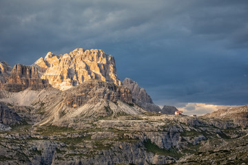 Last light on mountain Punta dei Tre Scarperi and the Three Peaks Hut in the Dolomites, South Tyrol, Italy