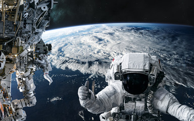 Fototapeta na wymiar Astronauts and the ISS in orbit of the planet Earth. Solar system. Science fiction. Elements of this image furnished by NASA