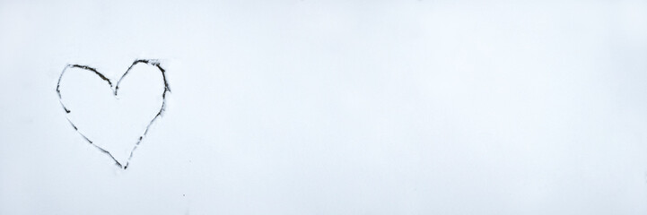 Heart drawn by stick on white snow . Beautiful winter background for Valentines Day or Christmas with copyspace. Stock photo.