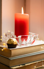  A stack of books, a red candle, candy and lights