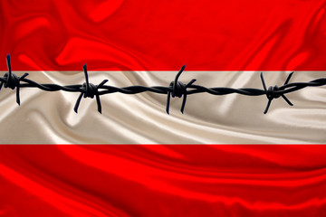 iron barbed wire against the background of the national silk flag of the state of austria, concept...