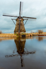 Windmills and a heavily cloudy sky in the winter, on the waterfront in Kinderdijk a national heritage in the Alblasserwaard