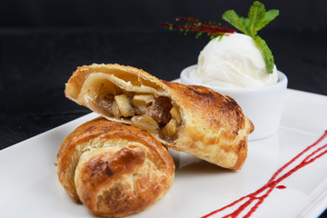 Apple strudel with vanilla ice cream decorated with caramel and berries sauce