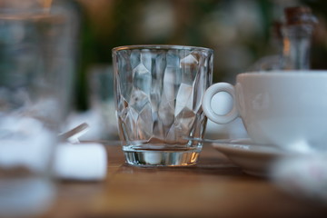 Empty transparent glass cup on a wooden table in a restaurant.