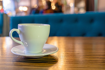 A white Cup of tea on a wooden table in a cafe close-up. 