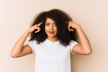 Young african american woman focused on a task, keeping forefingers pointing head.