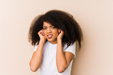 Young african american woman covering ears with hands.