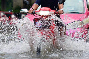 more floods and flooded motorcycle ,motorcycle driving flood water on a road