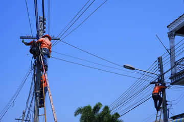 Low angle view of technicians group on wooden ladder are working to install telephone wires on...