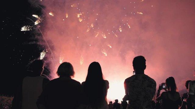 People silhouettes on a background of fireworks. group of people enjoying the city night view and fireworks