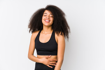 Young african american sporty woman touches tummy, smiles gently, eating and satisfaction concept.