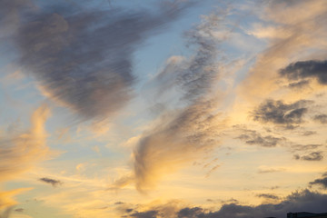 Naklejka na ściany i meble The evening sky with orange sunlight and white clouds.