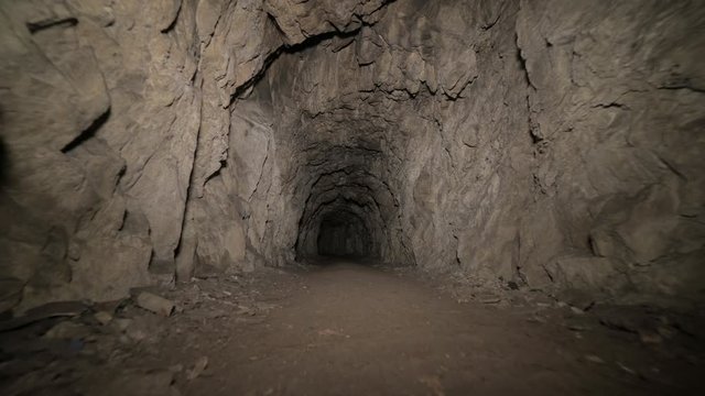 Speleology artificial cave dark tunnel excavation underground. Old adit for the extraction of metal and rocks