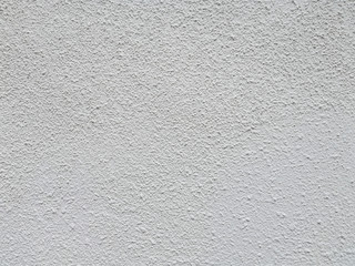 White stucco wall with large bump texture.